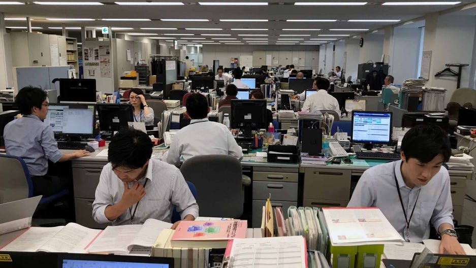 2 Picture displaying the daily Japanese work culture in a typical office with employees sitting at their desks