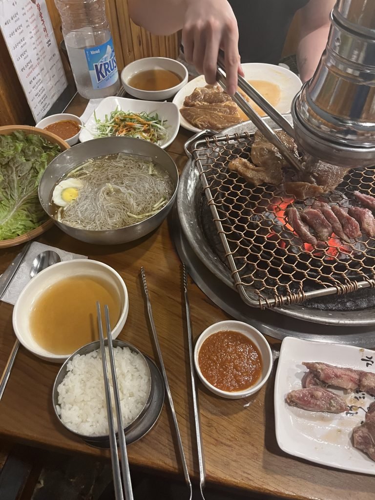 Korean BBQ dinner with naengmyeon, rice, and grilled meat on the table – a favorite student experience while studying abroad in Seoul, South Korea.