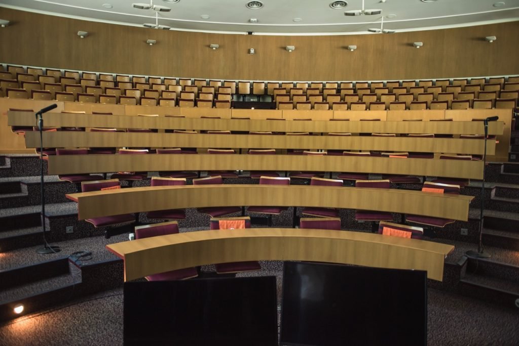 Lecture room at Assas University Singapore with curved tables, chairs, and a windowless interior designed for focused learning.