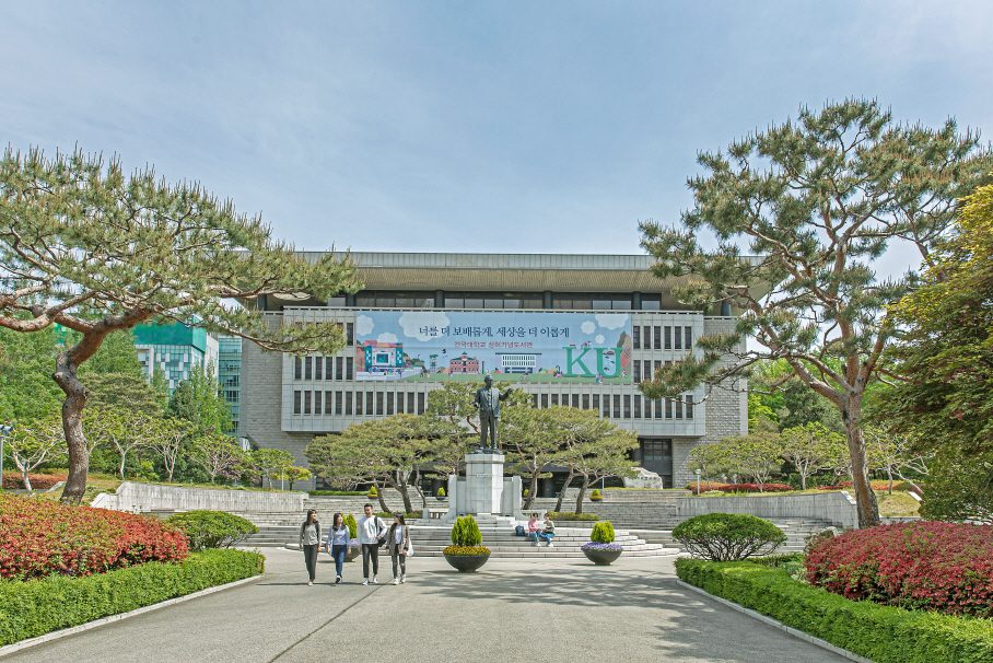 A scenic view of Konkuk University in Seoul, South Korea, featuring a statue, landscaped gardens, and students walking, highlighting the vibrant atmosphere for those who wish to study in Seoul.