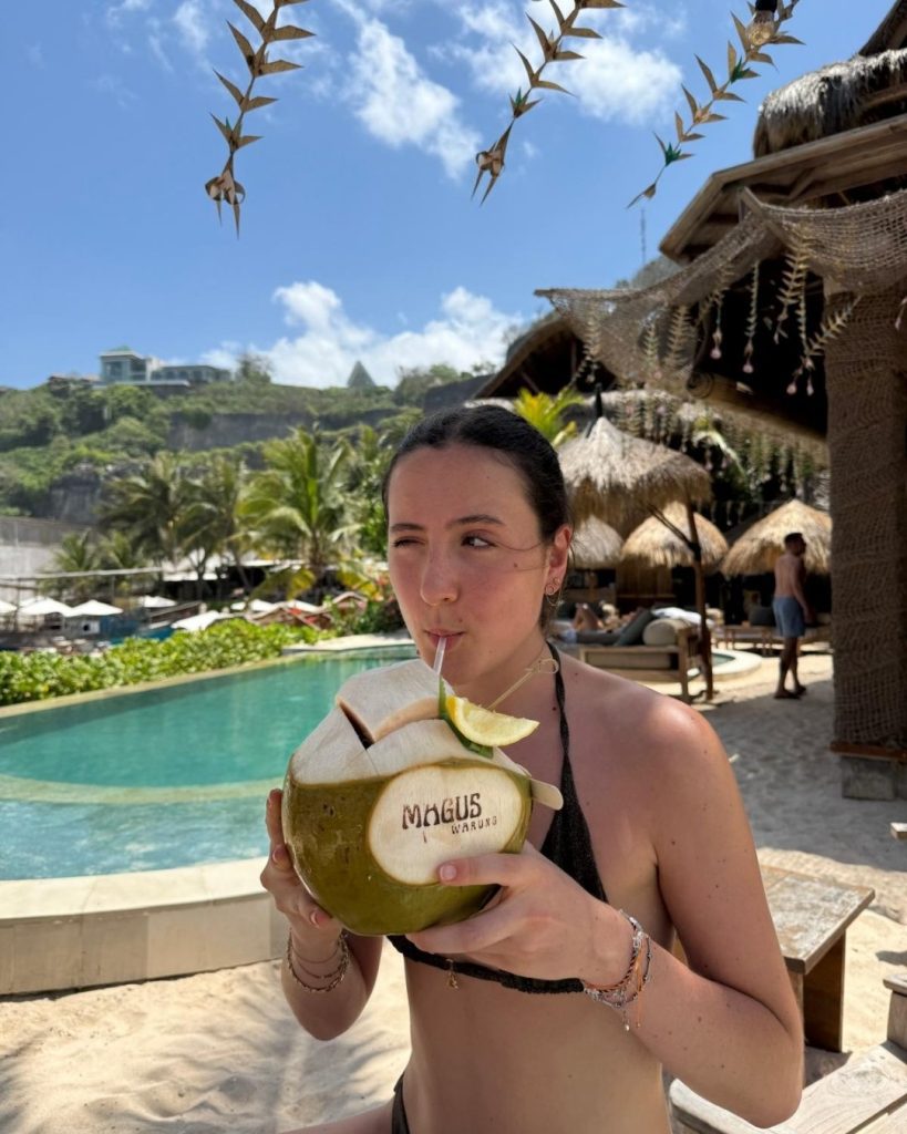 Emma enjoying a coconut by the pool during her gap year in Bali, Indonesia